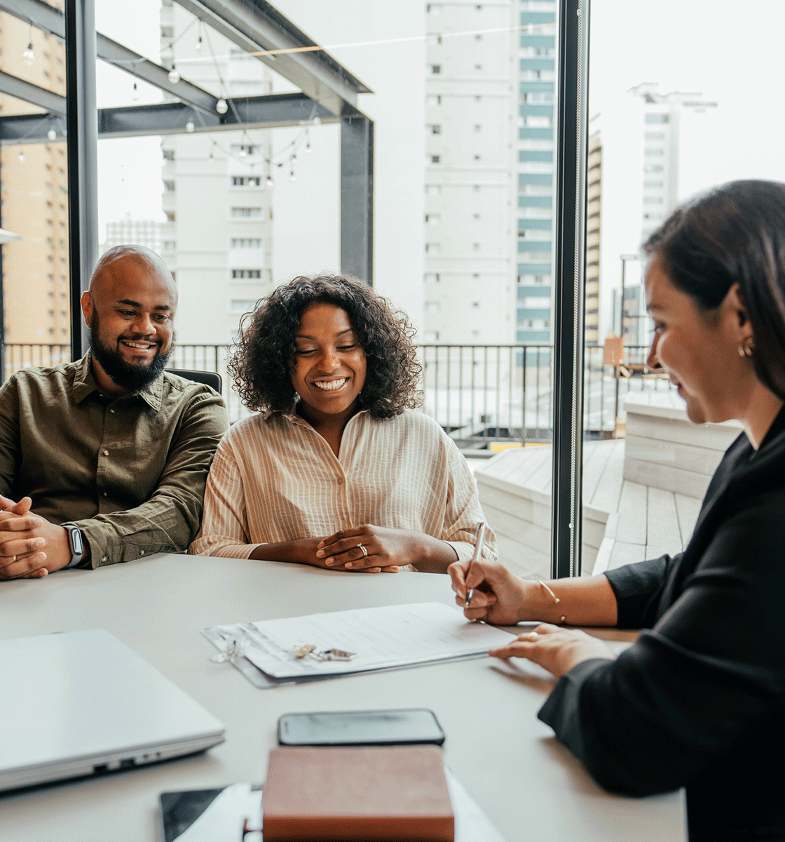Couple at a mortgage closing in an office with a mortgage professional