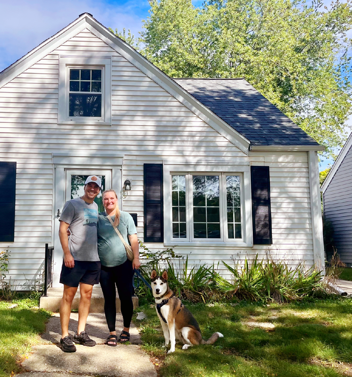 man and woman with dog in front of single family home