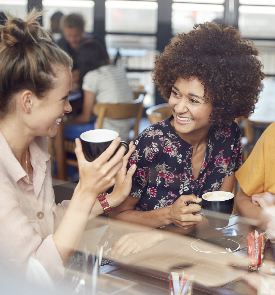 two women laughing in coffee shop